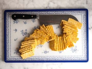 Thinly sliced tempeh on a cutting board.