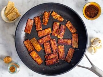 Tempeh bacon on a skillet.