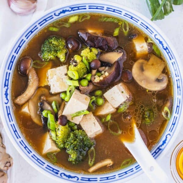 Tofu soup with mushrooms, broccoli, and peas.