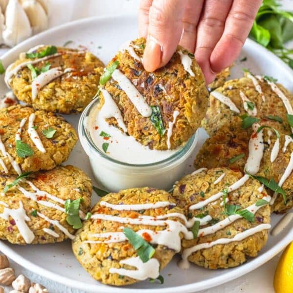 chickpea fritters with a hand and tahini sauce.
