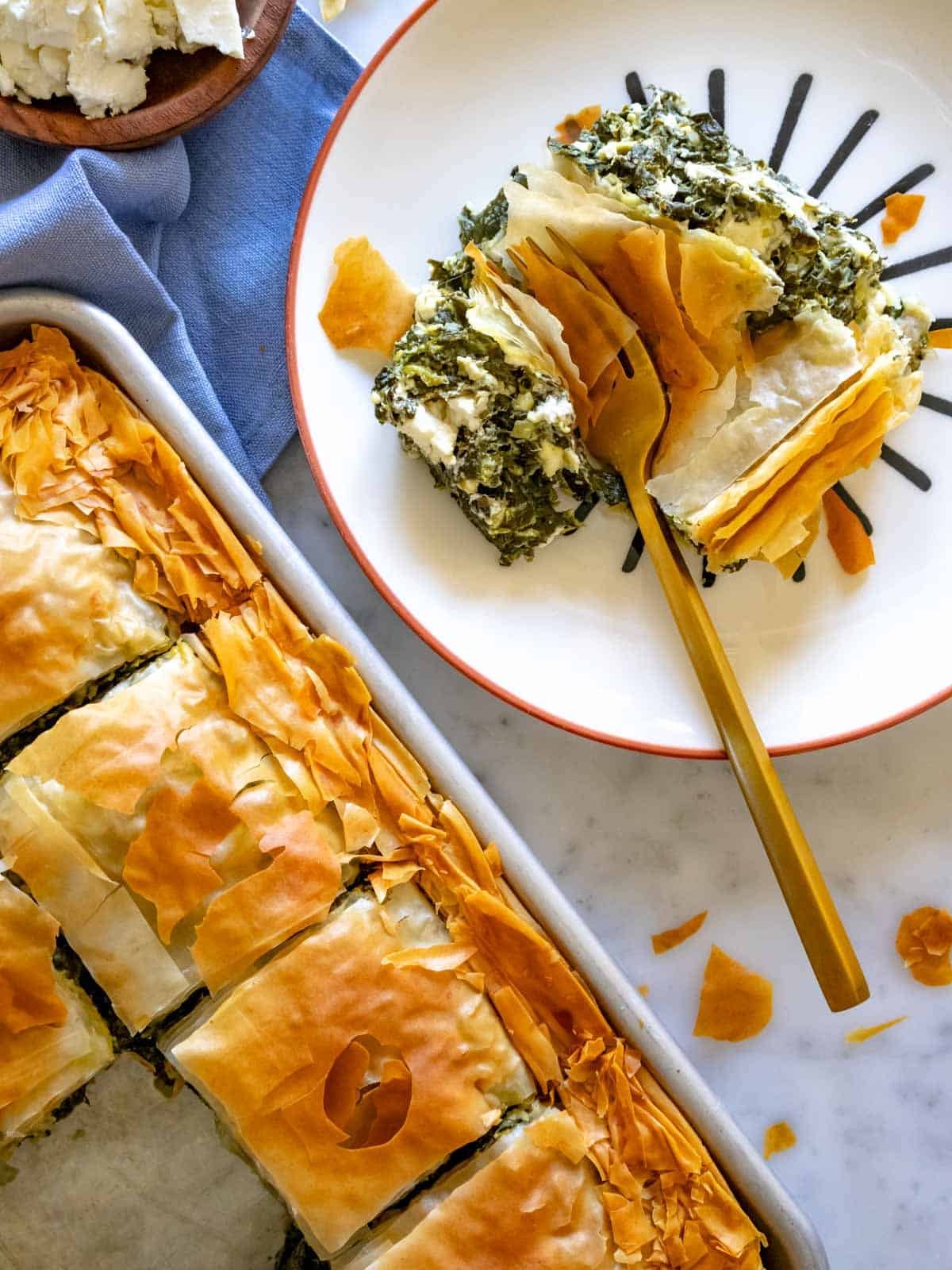 A slice of Greek spanakopita on a plate.