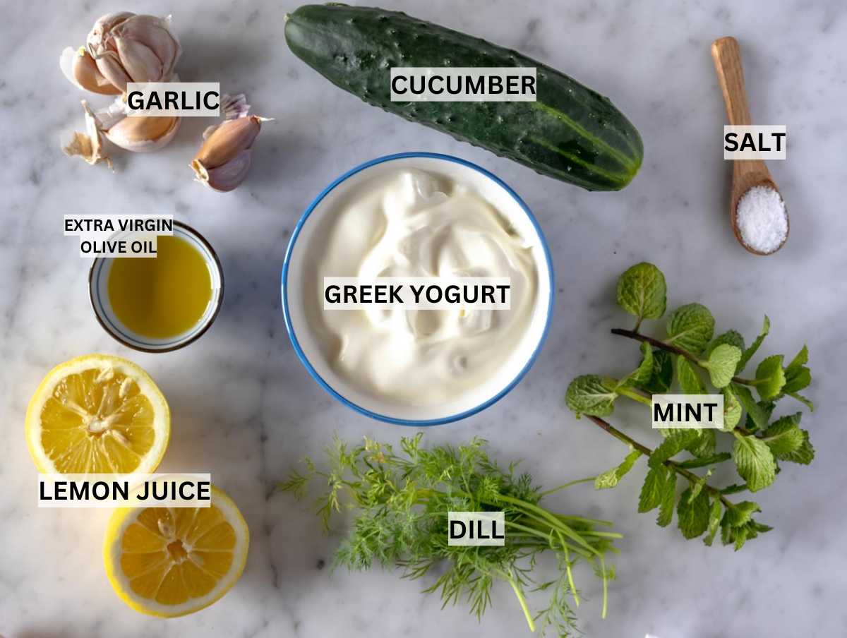 Ingredients for tzatziki prepared on a marble table.