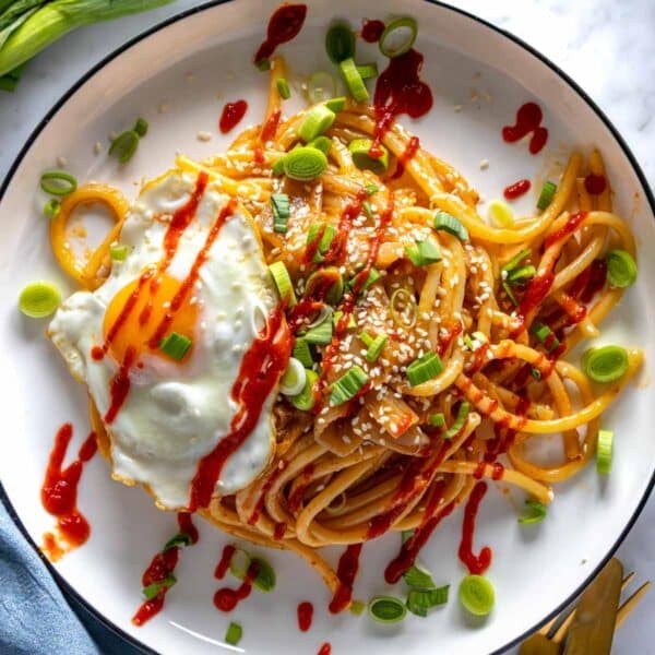 Miso pasta with a fried egg and sriracha sauce.