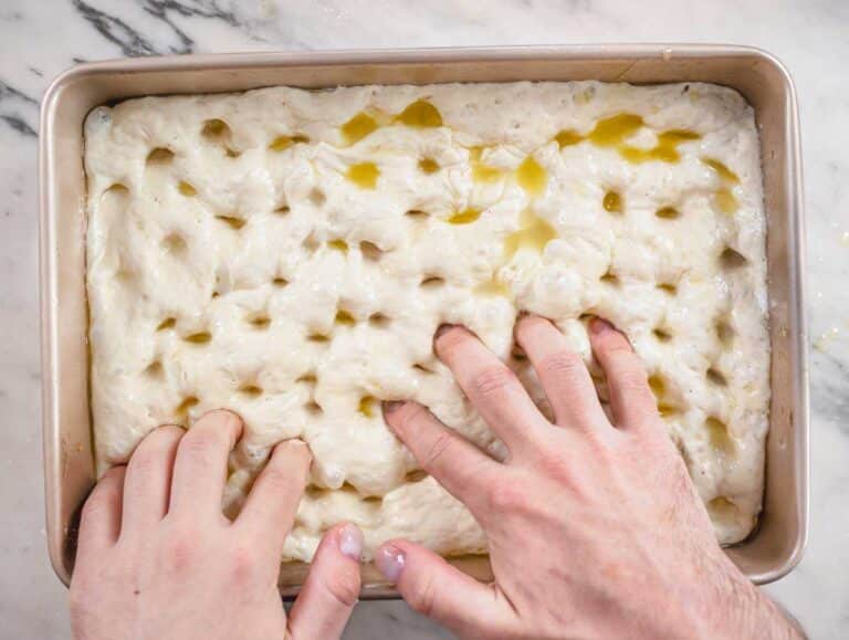 Nico making dimples in the focaccia dough.