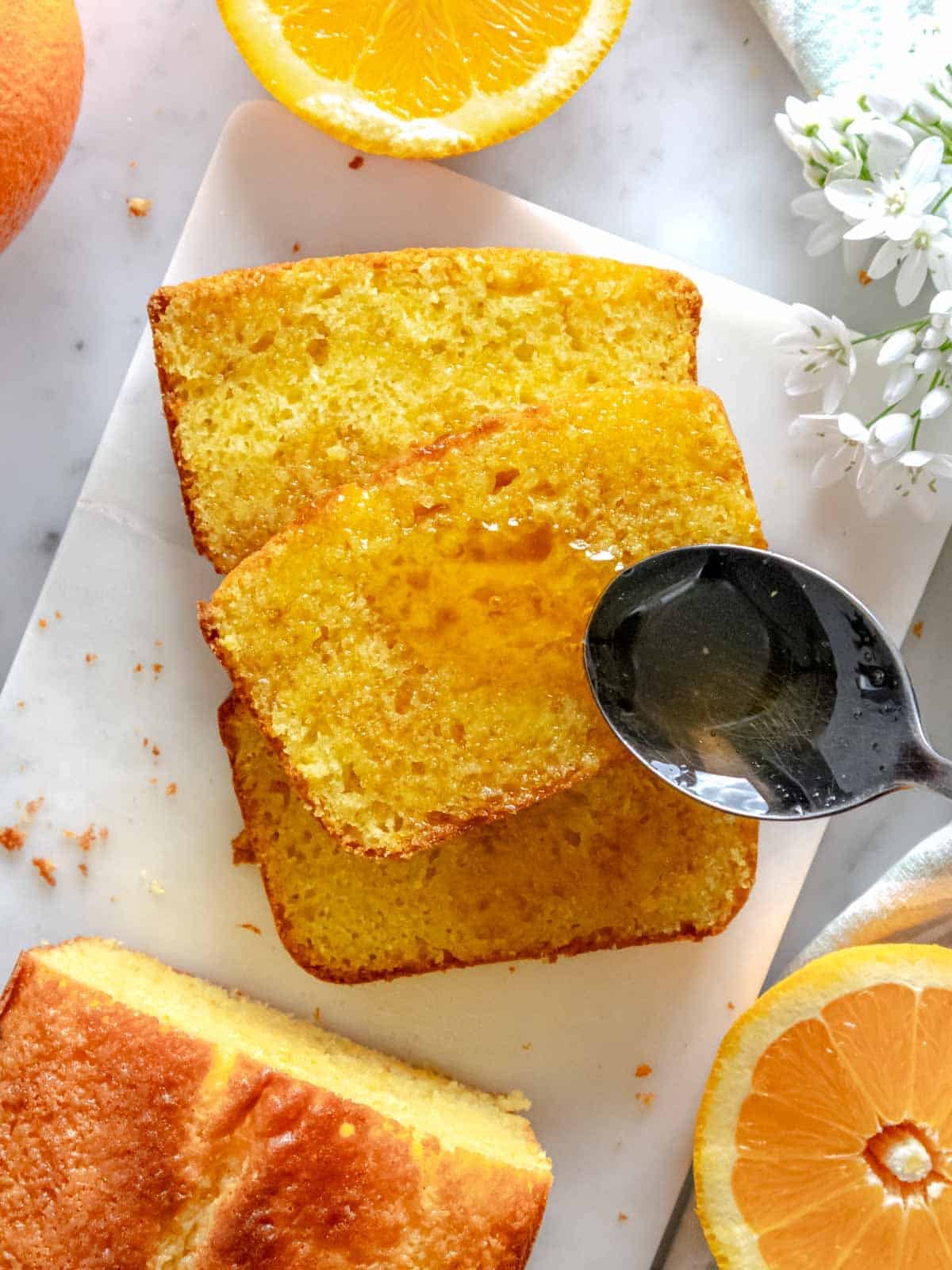 Warm orange syrup drizzled over a slice of orange cake.