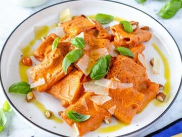 Roasted red pepper sauce with pasta and basil.