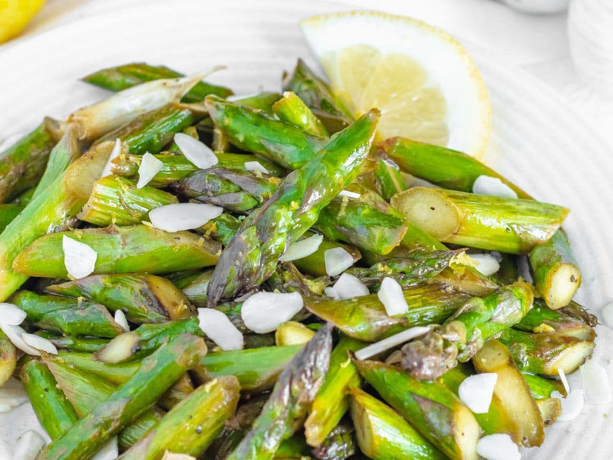 Sauteed asparagus with a slice of lemon.
