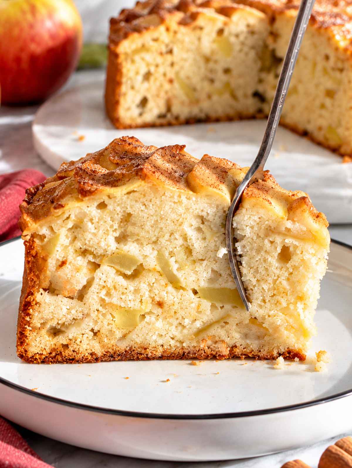 Sliced vegan apple cake showing tender crumb packed with soft apples.