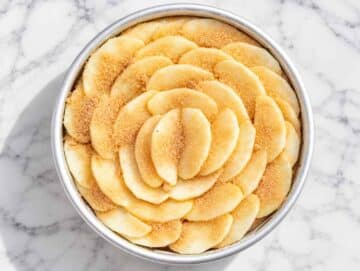 Step 3 Unbaked vegan apple cake topped with overlapping cinnamon apple slices.