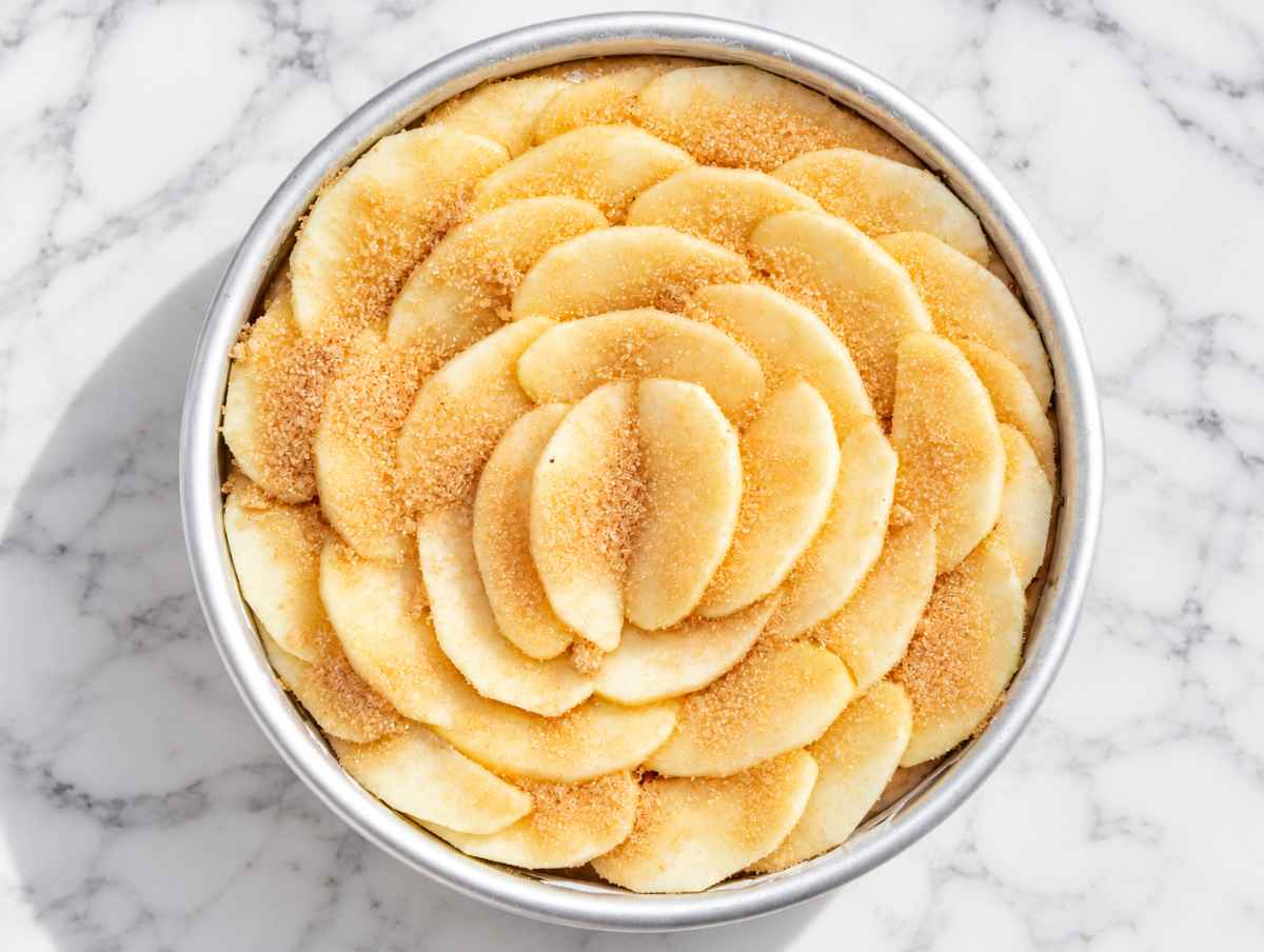 Step 3 Unbaked vegan apple cake topped with overlapping cinnamon apple slices.