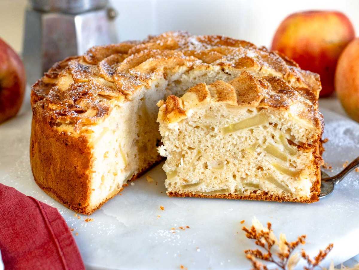 Vegan apple cake cut on a marble cutting board.