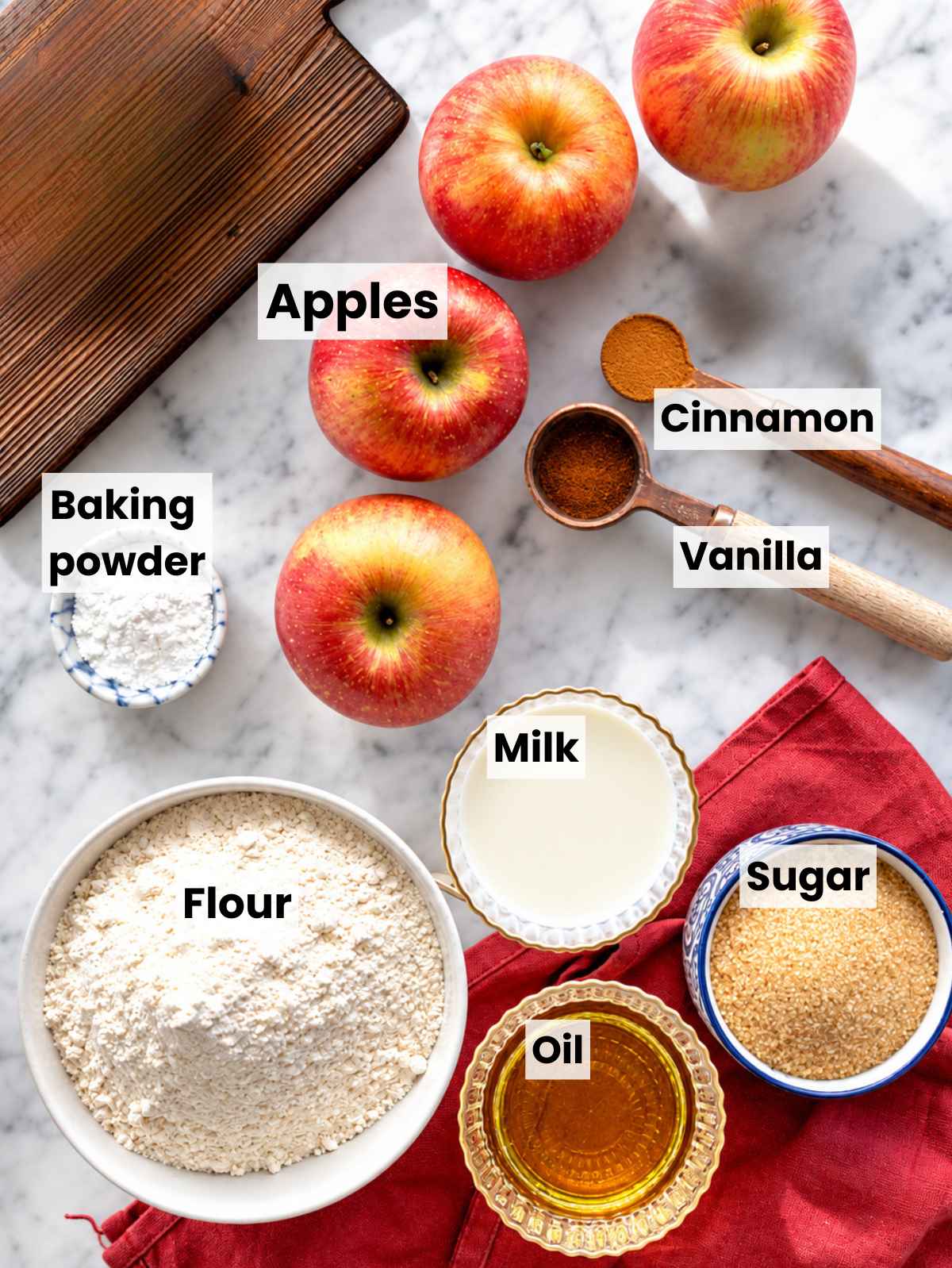 Vegan apple cake ingredients arranged on a marble surface in natural light.