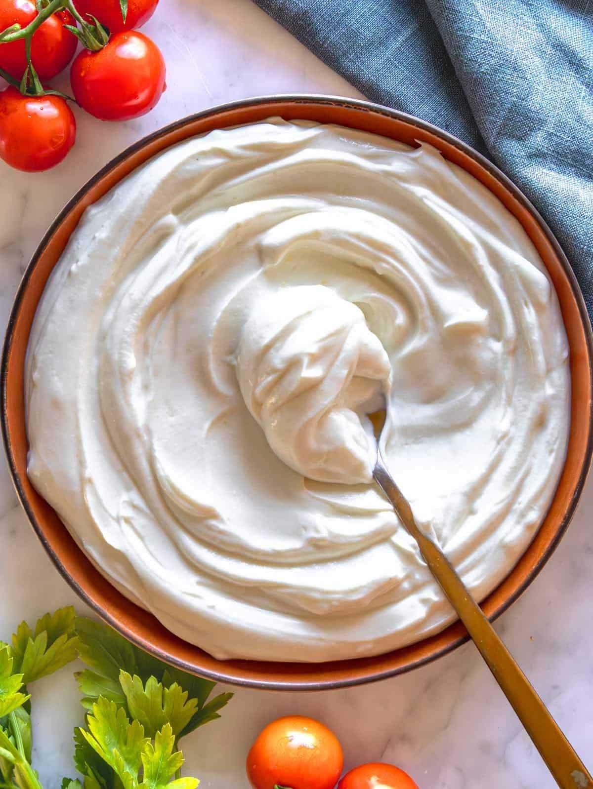 Whipped ricotta on a terracotta plate.