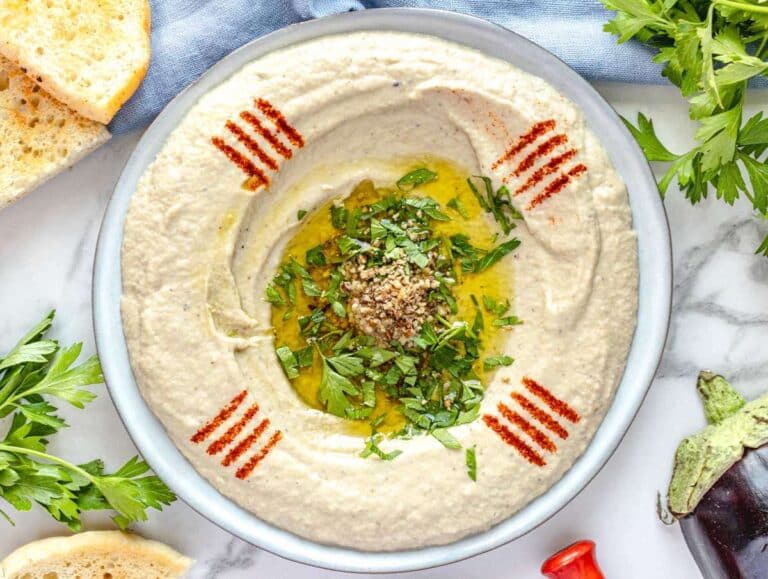 Baba ganoush on a plate topped with olive oil, parsley, and paprika.