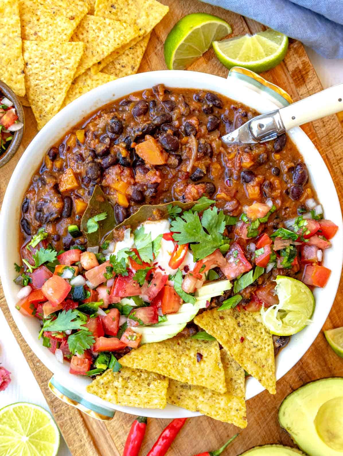 Black bean soup topped with pico de gallo and sliced avocado