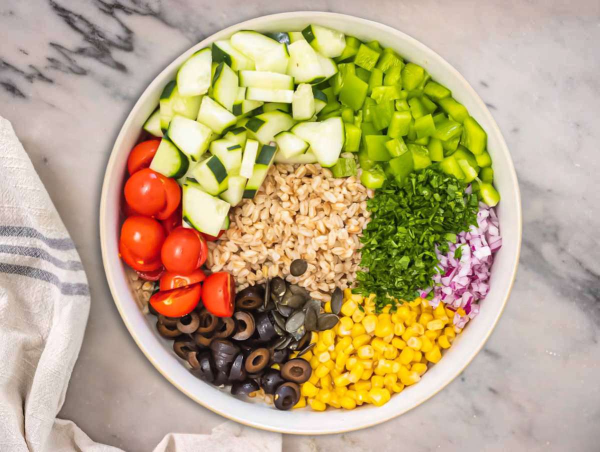 Chopped vegetables and farro in a large bowl.