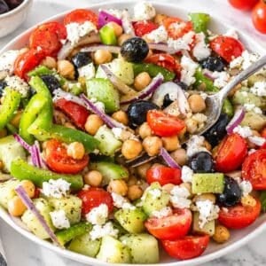 Fresh Greek chickpea salad with feta, olives, vegetables, and oregano dressing.