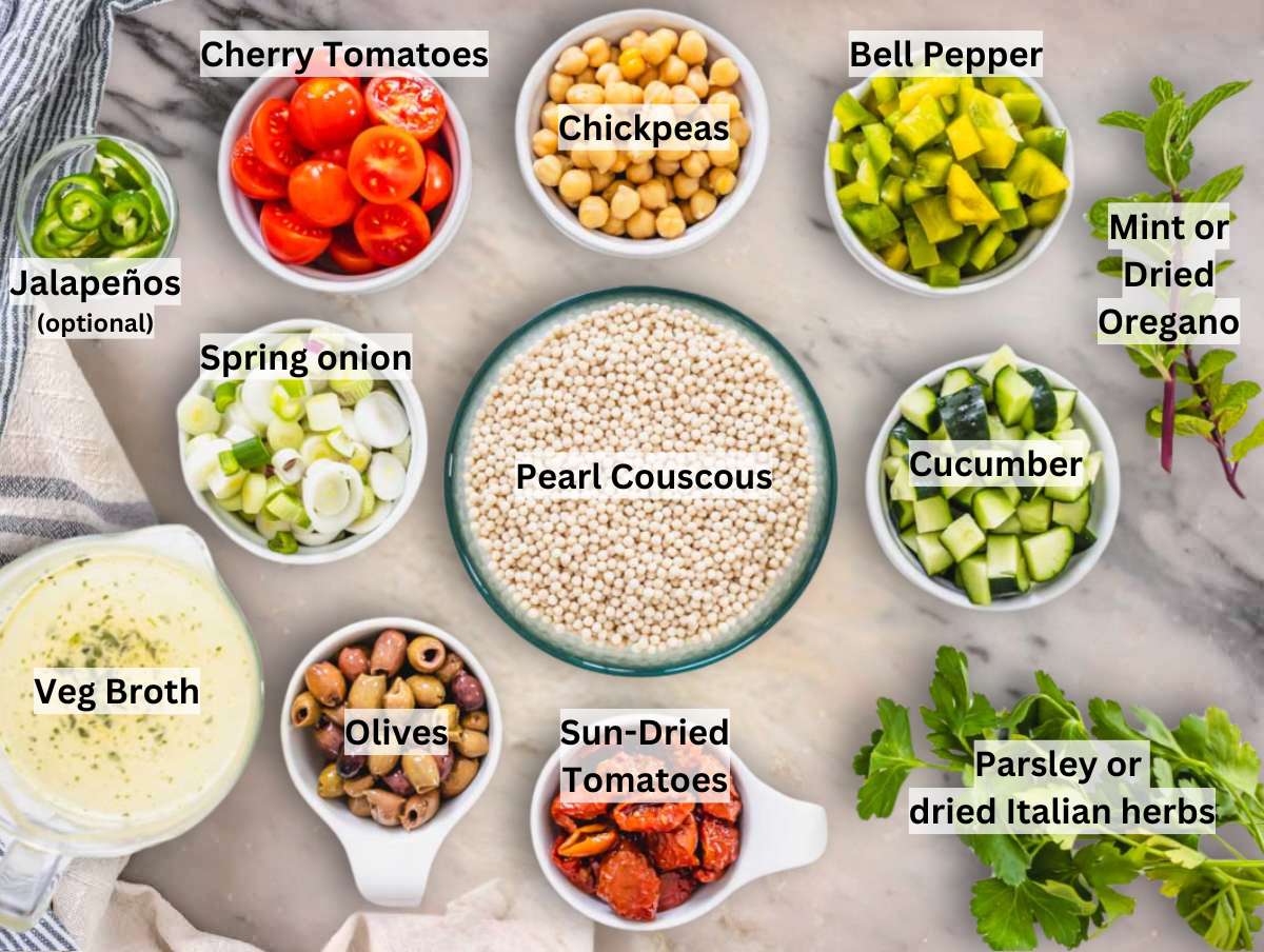 Ingredients for pearl couscous salad on a marble table.