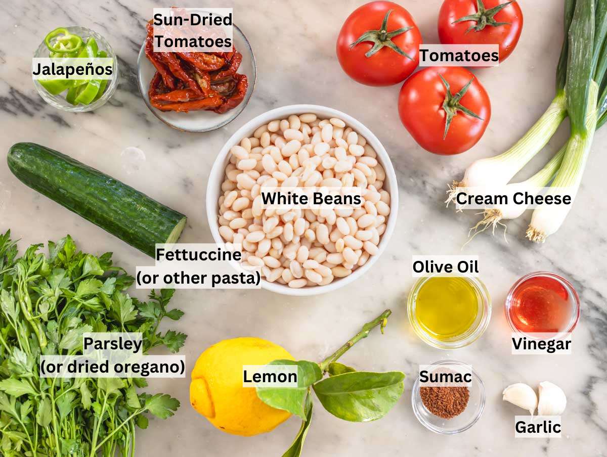 Ingredients for white bean salad on a marble table.