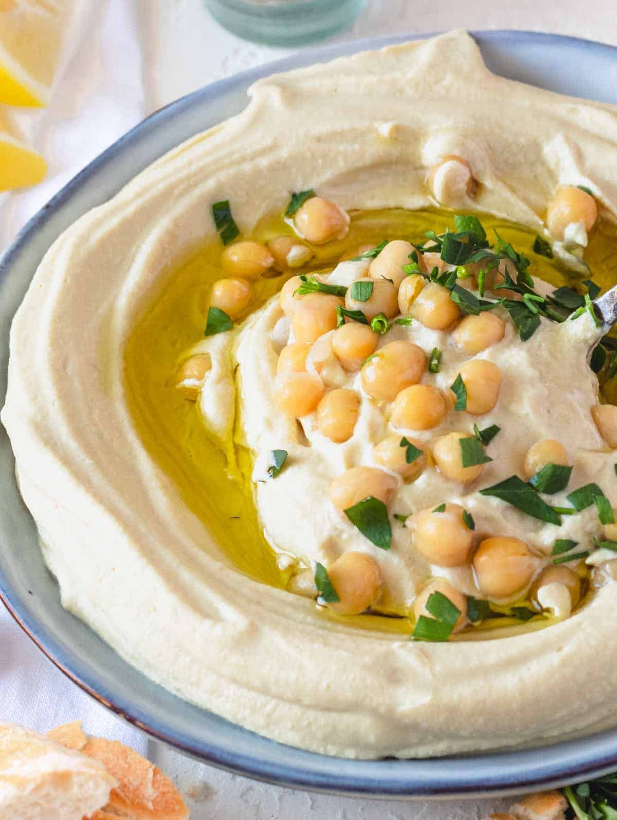 Smooth hummus topped with chickpeas and olive oil