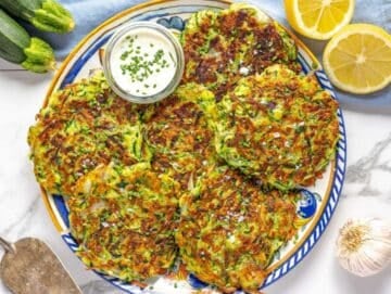 Step 5 Serving the zucchini fritters on a platter with fresh lemon.