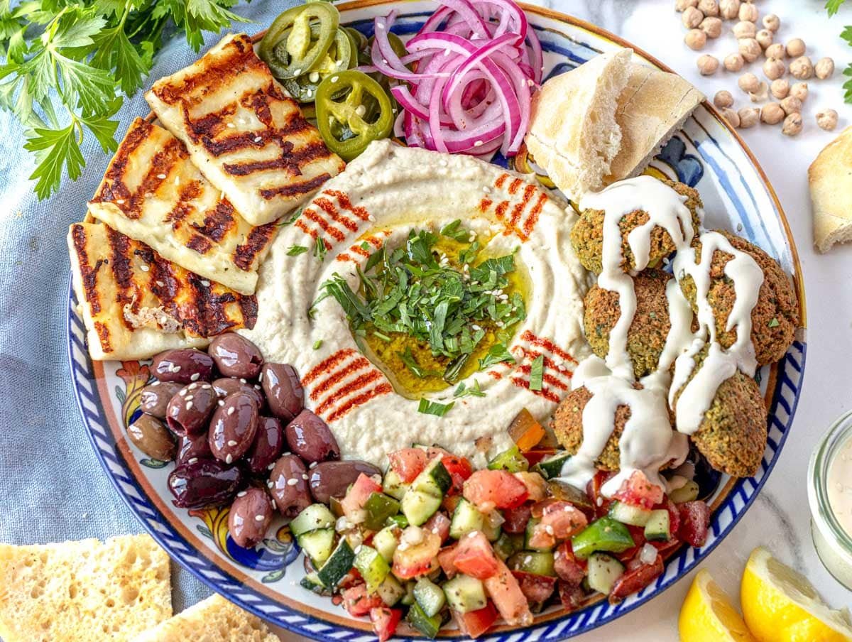 Tahini sauce drizzle over a meze platter with falafel and hummus