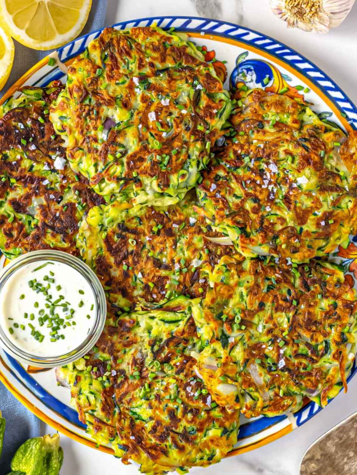 Zucchini fritters on a platter served with lemon.