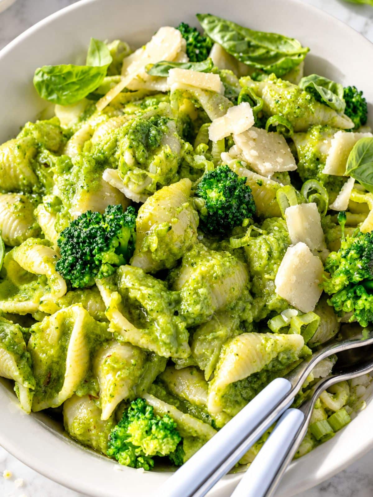 Close up of broccoli pasta with creamy sauce, tender florets, and Parmesan.