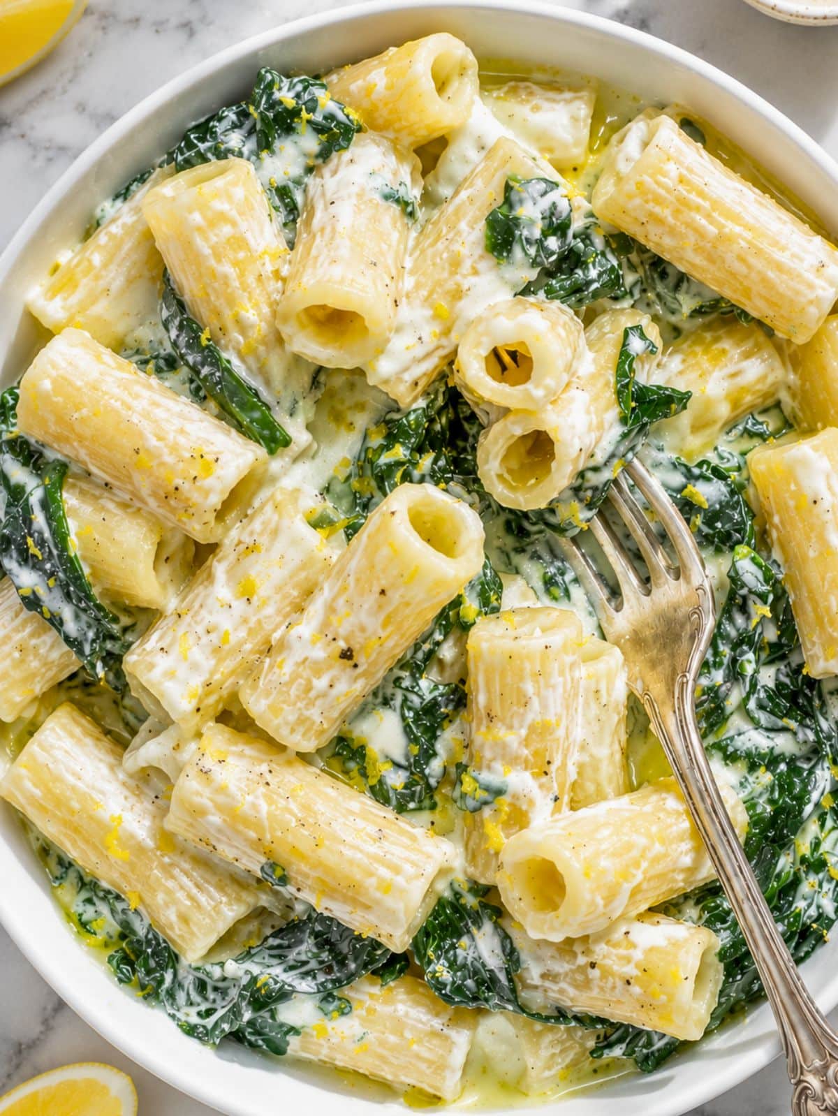 Close-up of glossy rigatoni coated in creamy lemon ricotta sauce.