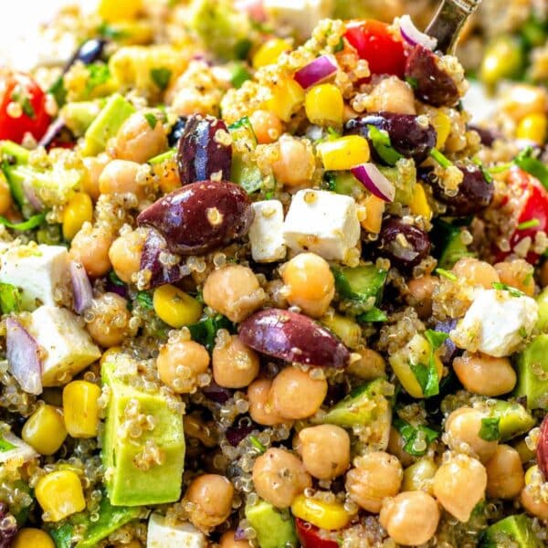 Colorful quinoa chickpea salad served with a large silver spoon.