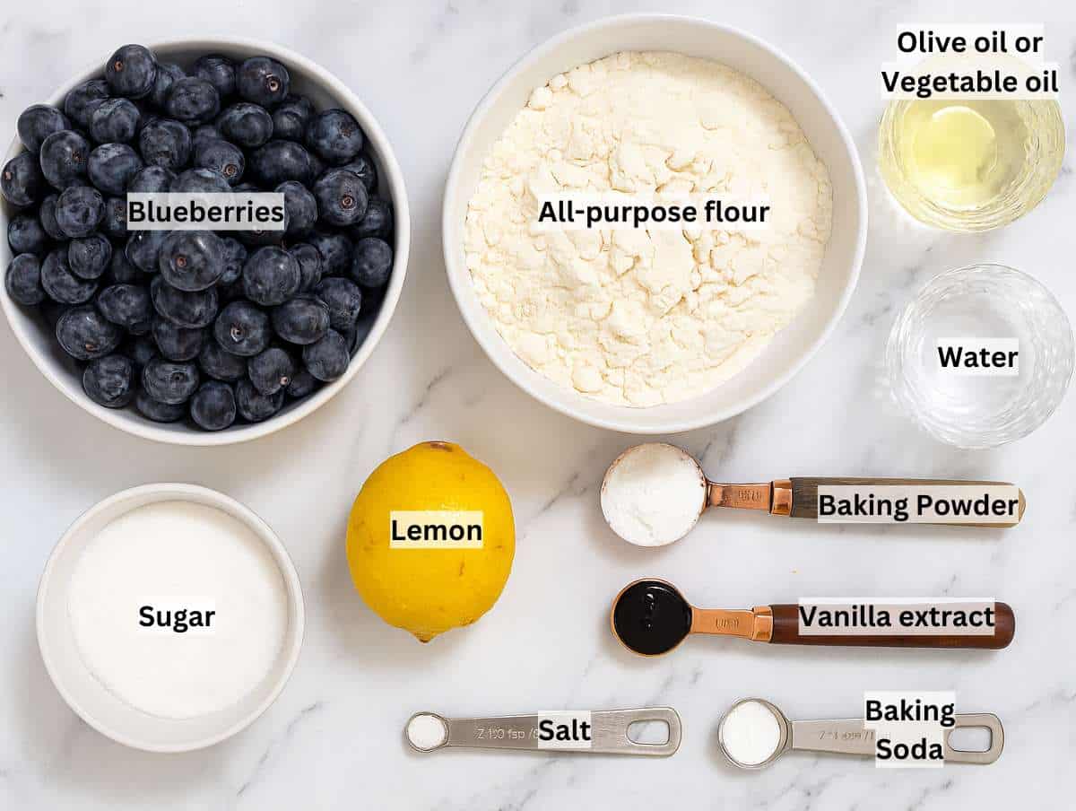 Ingredients for blueberry tart on a marble table.