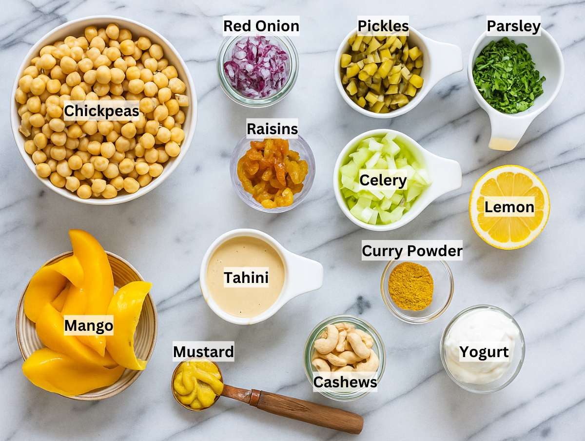 Ingredients for curry chickpea salad on a marble table.