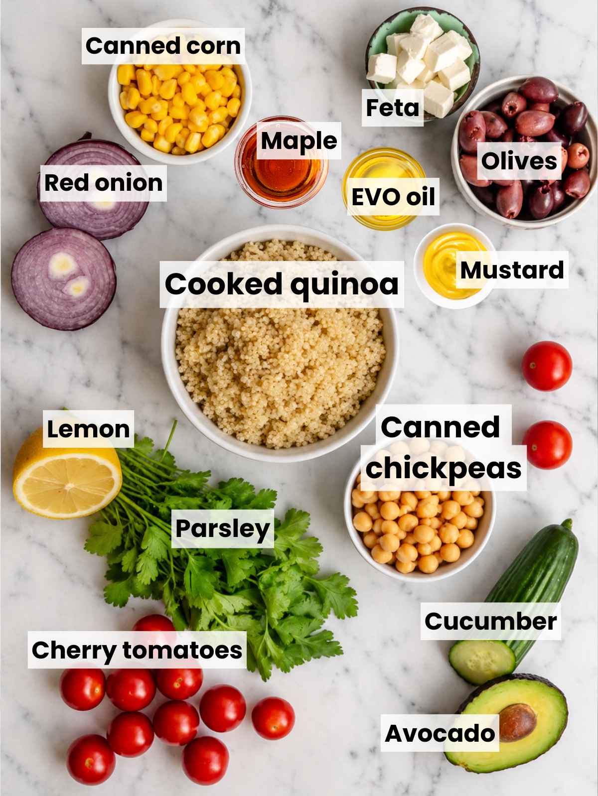 Quinoa chickpea salad ingredients arranged on a bright carrara marble surface.