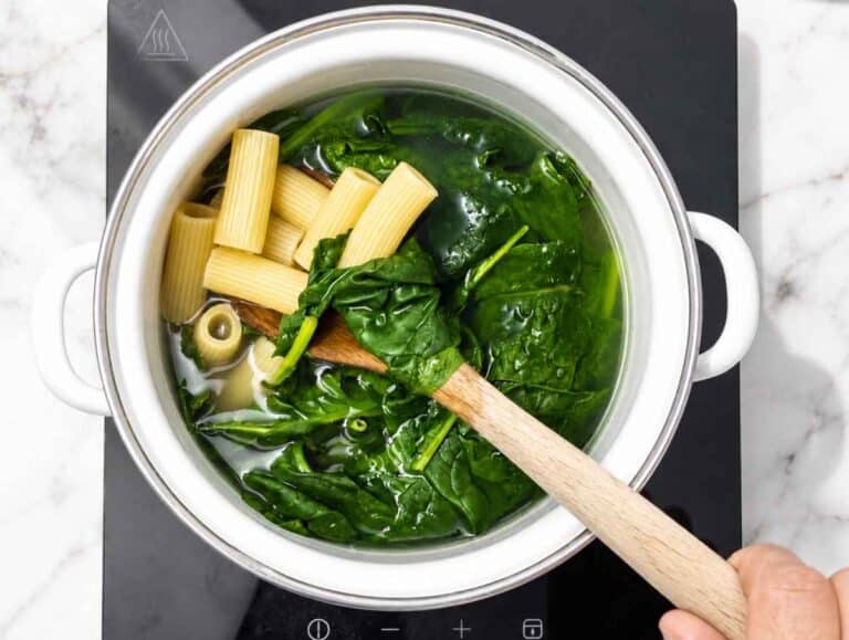 Step 1 rigatoni and baby spinach cooking together in salted boiling water.