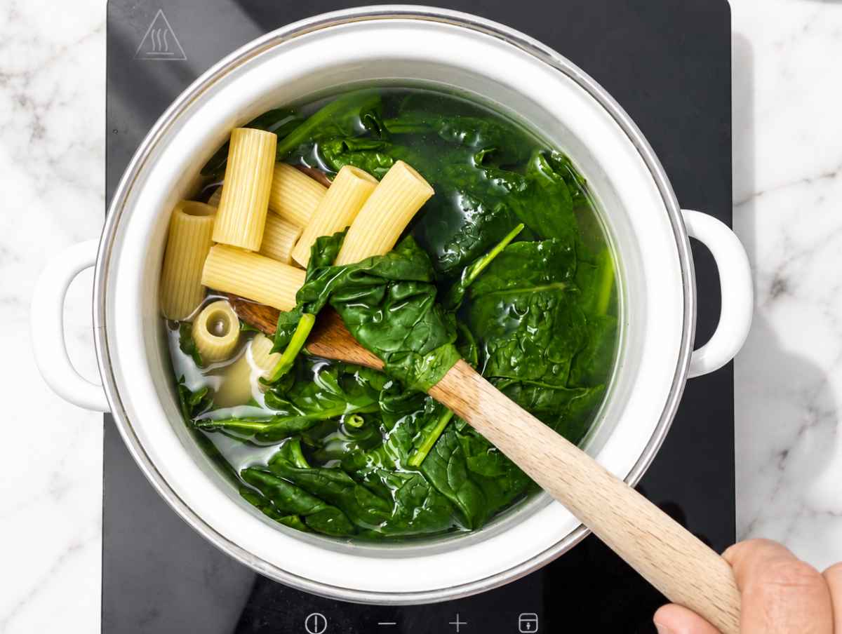 Step 1 rigatoni and baby spinach cooking together in salted boiling water.