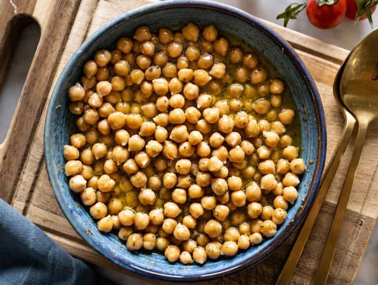 Step 2 Chickpeas marinating in lemon mustard dressing in a ceramic bowl.