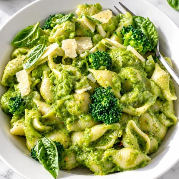 Vibrant broccoli pasta with glossy green sauce and Parmesan in natural light.