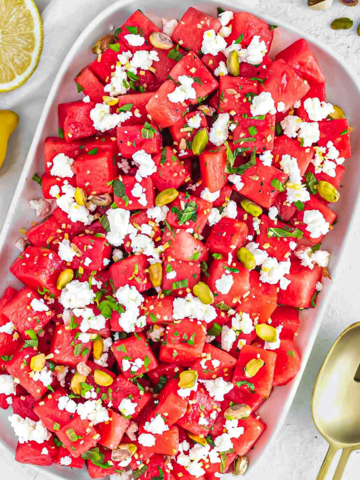 Watermelon feta salad on a platter with mint and pistachios.
