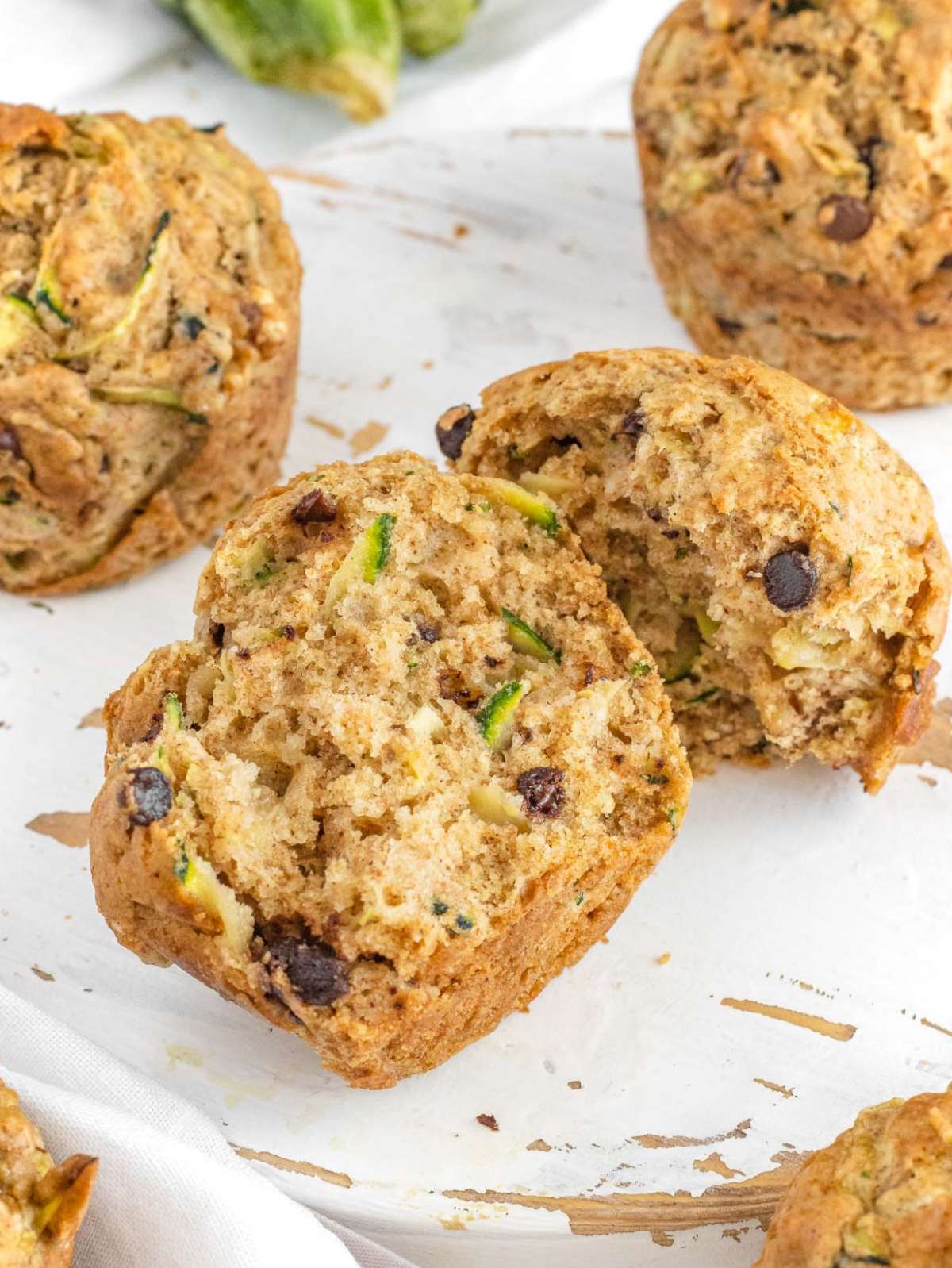 Zucchini muffin open in half showing the soft crumb.