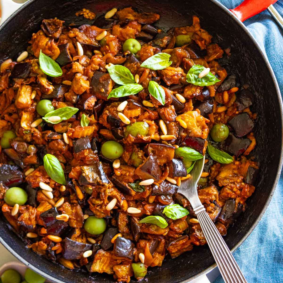 Authentic Sicilian caponata recipe styled in a skillet with a spoon, perfect as a Mediterranean side or plant-based appetizer.