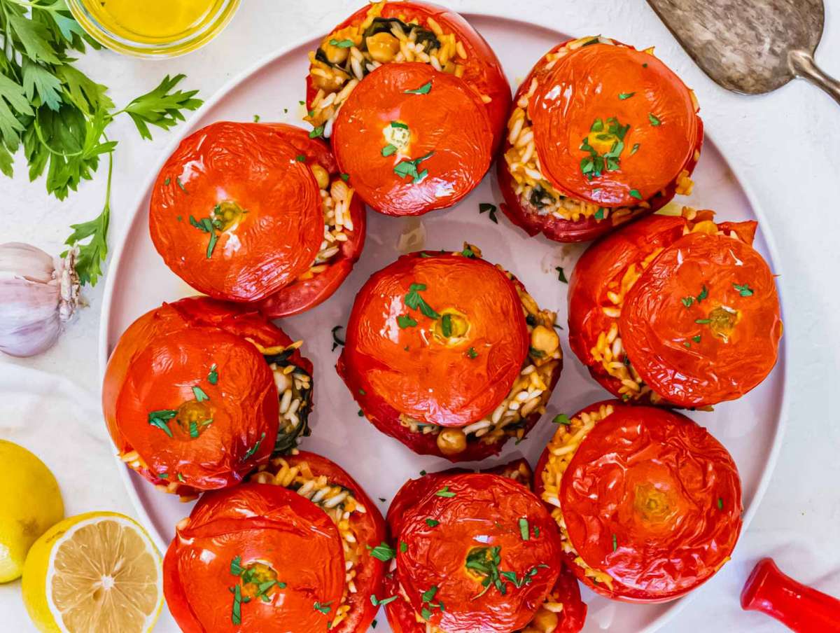 Baked stuffed tomatoes fresh from the oven, served warm with herbs.