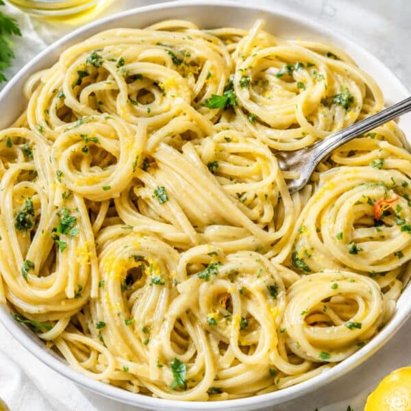 Bowl of Lemon Pasta on white marble with silver fork.
