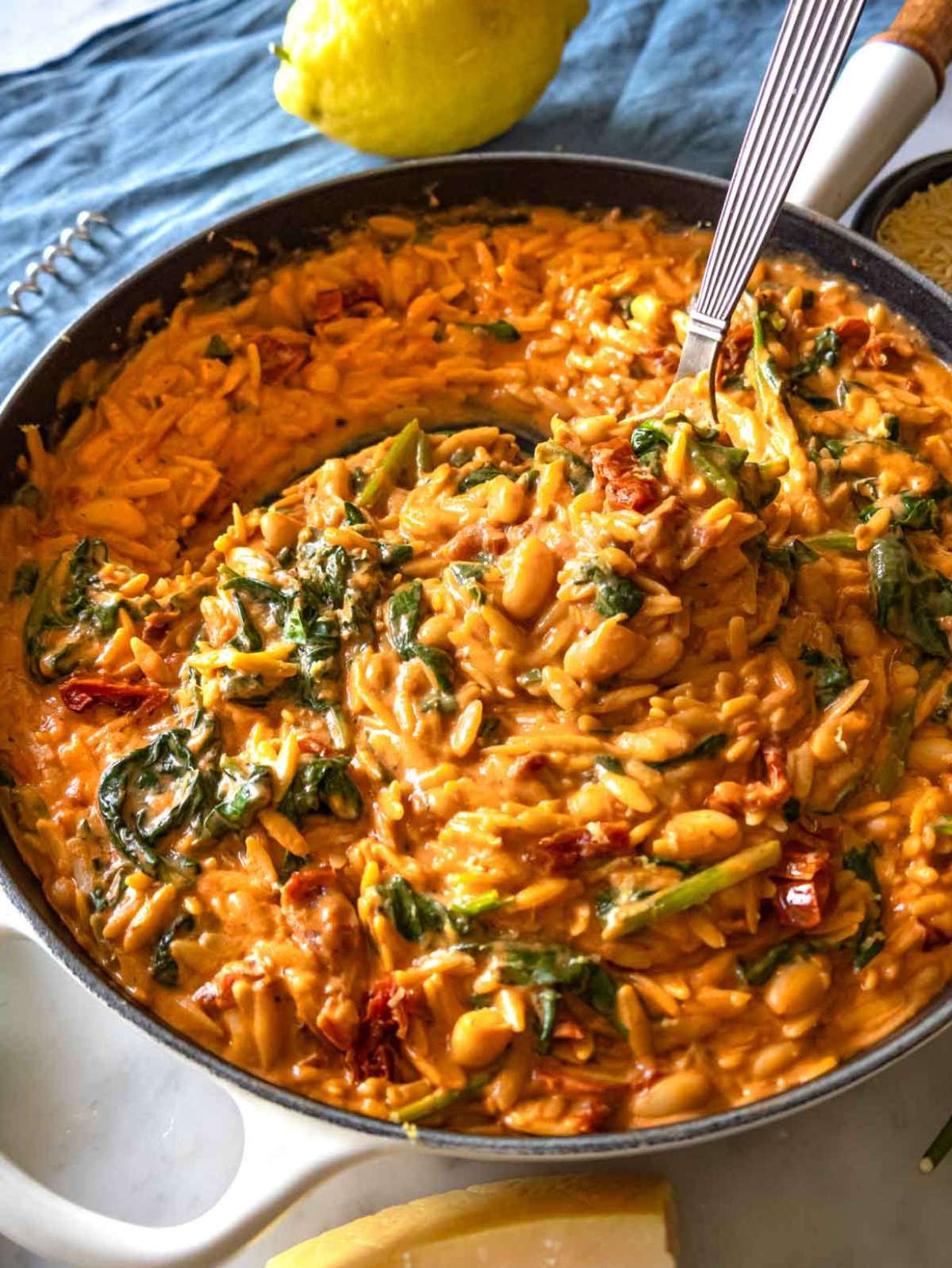 Close-up of creamy Marry Me Orzo with sun-dried tomatoes and spinach.