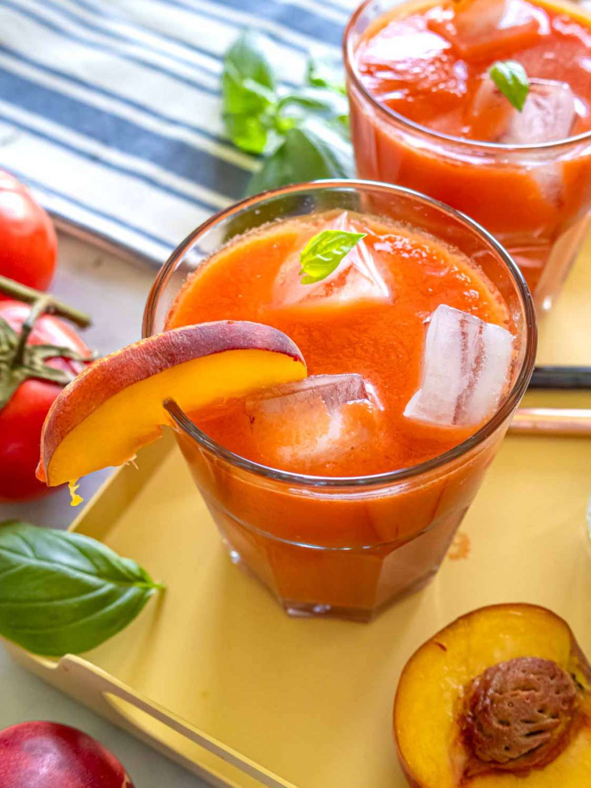 Close-up of creamy peach gazpacho served in glasses over ice.
