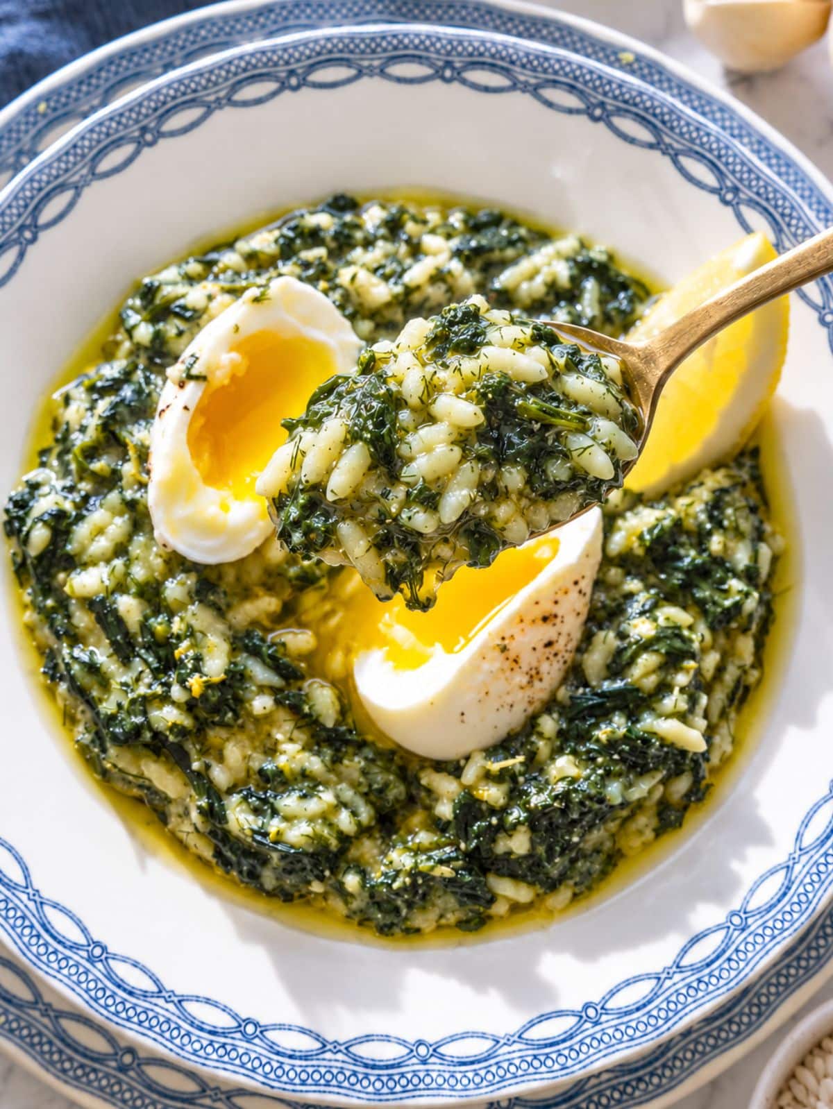 Close-up of glossy spanakorizo with creamy rice, spinach, boiled eggs, and dill.