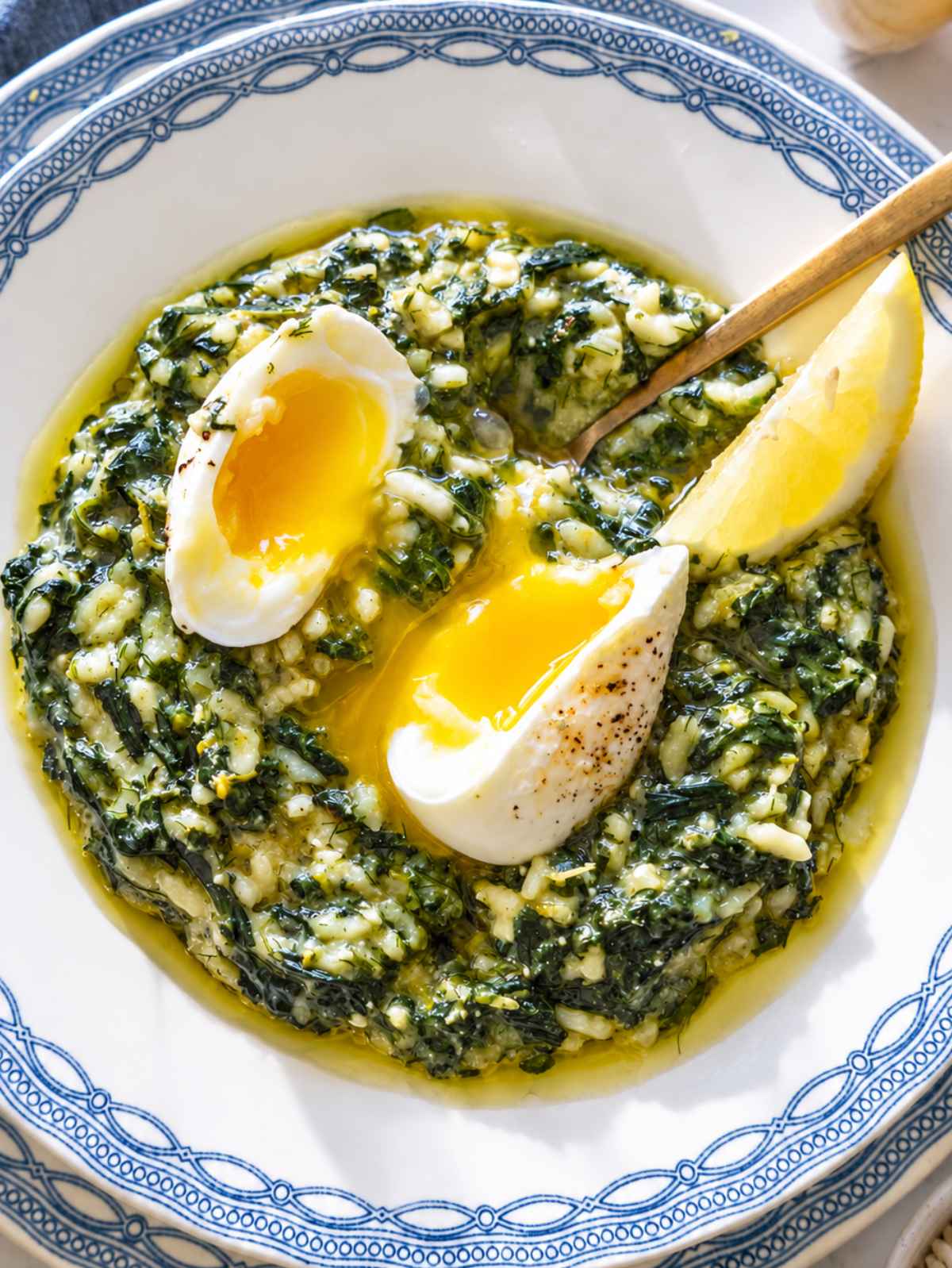 Close-up of glossy spanakorizo with creamy rice, spinach, jammy eggs, and dill.