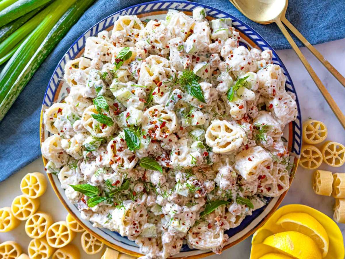 Cold pasta salad plated and garnished with herbs and Aleppo pepper.