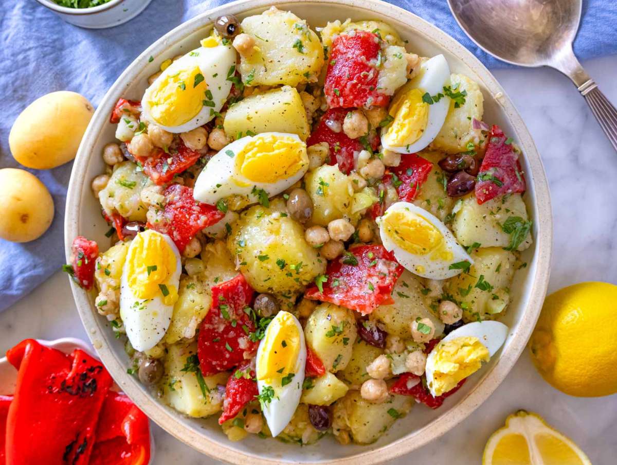 Colorful Italian potato salad served in a bowl, chilled and garnished with fresh herbs.