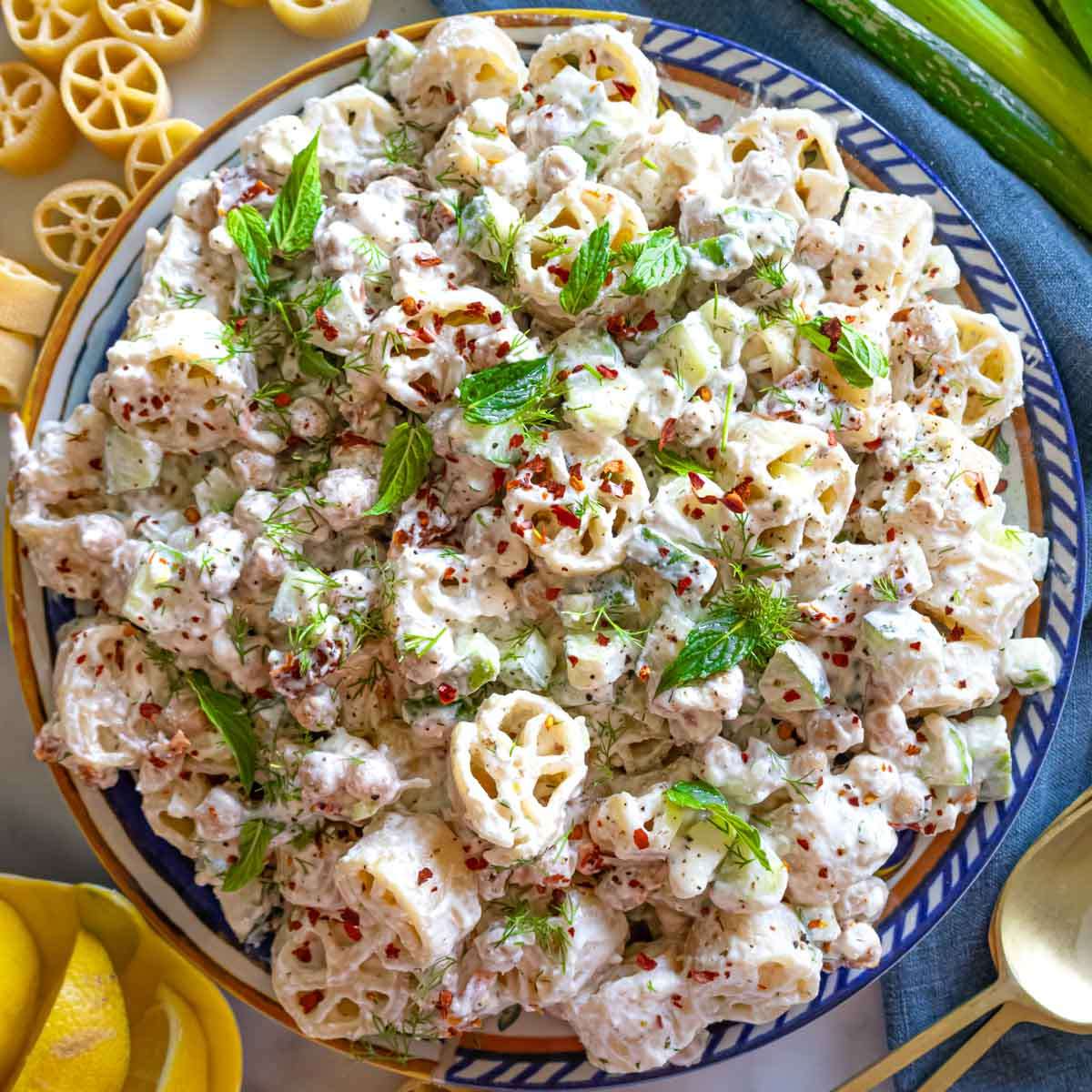 Colorful cold pasta salad in a bowl with herbs, ideal for summer lunches and picnics.