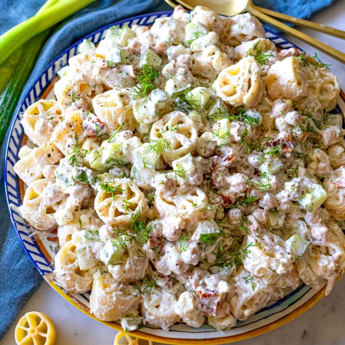Colorful cold pasta salad with chickpeas and creamy yogurt dressing, perfect for a healthy summer meal.